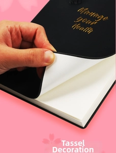 Dettaglio di un’agenda fitness nera con scritte dorate e nappa decorativa