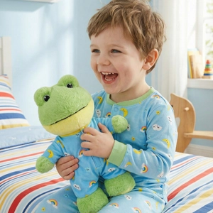 Cute green frog plush toy with matching star and moon pattern pajama set for kids