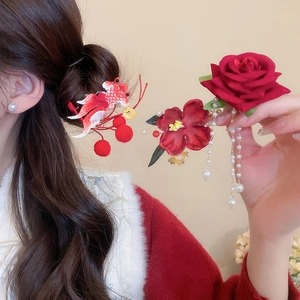 Detail of red fish embroidery and rose hair clip with long pearl tassels on model