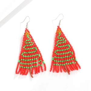 Detailed macro view of handmade beaded Christmas tree earrings with festive red and green beads