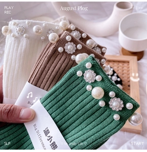 Close-up of ribbed knit socks with hand-sewn pearls and rhinestone floral decorations