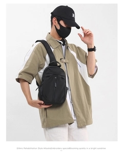 Detail of durable black nylon crossbody chest bag showing vertical zipper and padded strap