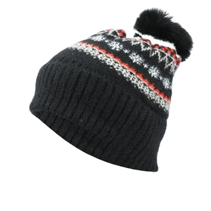 Close-up of winter knit hat with red snowflake patterns and black faux fur pompom