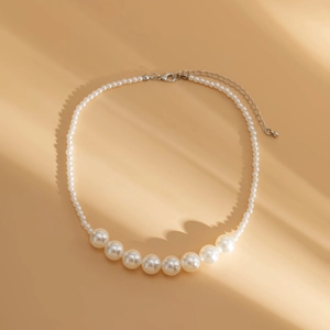 Detail showing gradient white pearls necklace with lobster clasp and adjustable silver chain