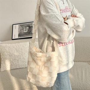 Shoulder bag with cream and brown checkerboard plush texture shown on a model