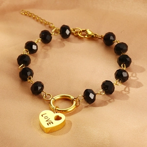 Bracciale retrò di perline con ciondolo a cuore LOVE nero e oro su sfondo di seta