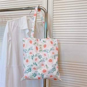 Détail de l'imprimé pivoine rose sur un sac fourre-tout minimaliste en coton blanc
