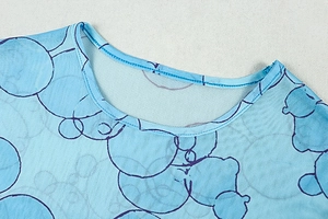 Close-up of the crew neck detail on a blue mesh dress with circular line patterns