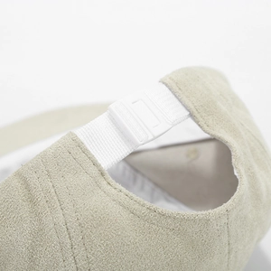 Detail view of the beige faux suede baseball cap with white adjustable back strap and buckle