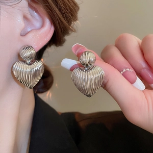 Silver heart earrings with vertical ribbed texture and minimalist geometric drop design