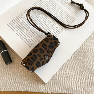 Detail of leopard print leather key case with vintage bronze snap and hand-stitched edges