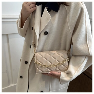 Quilted beige crossbody bag with gold chain strap shown on a wool coat outfit
