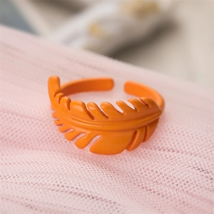 Macro shot of vibrant orange leaf-shaped enamel ring with adjustable open band detail