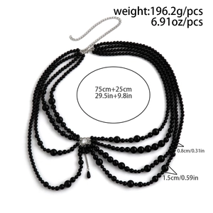 Detail view of multi-layer body chain with black pearls and metallic fringe tassels
