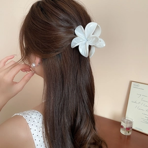 Vue détaillée d'une pince à cheveux fleur blanche portée par un mannequin de profil