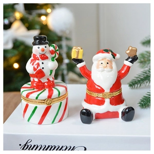 Ceramic Christmas tree and Santa jewelry boxes on white books with festive background