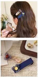 Dettaglio di fermagli per capelli floreali con tessuto blu scuro e resina marmorizzata