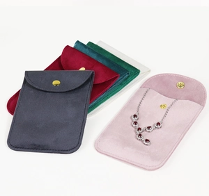 Various colored velvet jewelry pouches with gold snaps showing a necklace storage scene