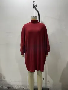 Detail of burgundy ribbed knit turtleneck dress showing texture and long lantern sleeves
