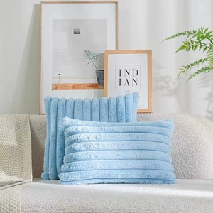 Detail of blue faux rabbit fur pillow covers with ribbed texture on a light sofa