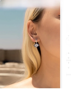 Close-up of S925 silver evil eye earring with blue zircon on a female model's ear