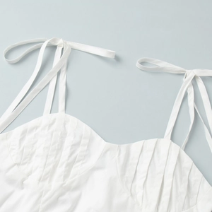 Détail du haut en coton blanc avec bretelles à nœuds ajustables et corsage plissé