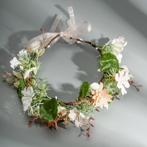 Detail of floral headpiece with pink and white artificial flowers and adjustable ribbon