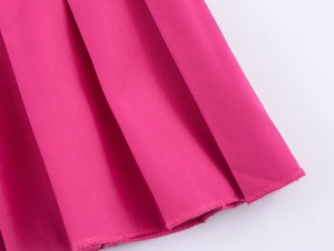 Detailansicht des Faltenrocksaums und der präzisen Nähte bei diesem Kleid in Rosa