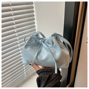 Detail of light blue bucket bag featuring soft pleated PU leather and a decorative bow