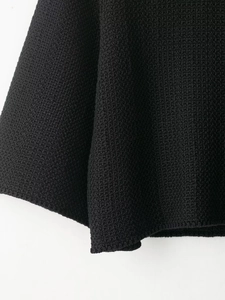 Detailed macro view of black chunky knit texture on minimalist fall sweater sleeves