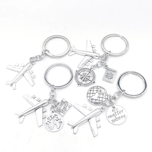 Silver travel keychain set with airplane, globe, compass, and passport charms