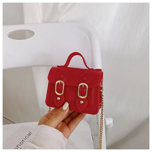 Detail of red glossy mini jelly bag with gold chains and double buckle hardware