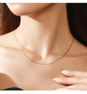 Close-up of minimalist S925 sterling silver heart snake chain necklace on model neck