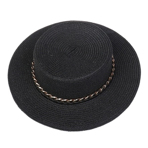 Macro detail of black straw fedora with decorative gold metal chain link trim