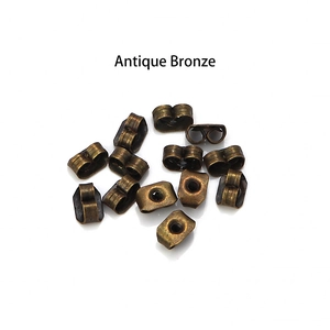 Flat lay of multiple antique bronze butterfly earring backs for DIY jewelry crafting