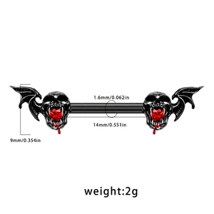 Macro detail of skeleton bat wing nipple ring with red heart gem and size measurements
