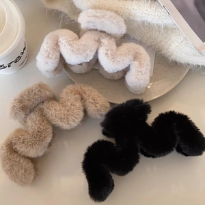 Detailansicht wellenförmiger Plüsch-Haarklammern in Schwarz, Beige und Cremeweiß