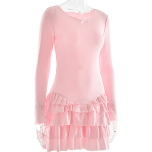 Detail of pink long sleeve dress showing delicate bow neckline and tiered ruffle hemline