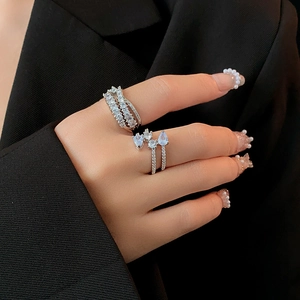 Model wearing a luxury silver zircon ring with teardrop stones over a black suit