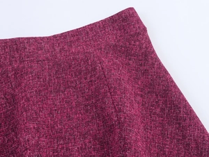 Detailed macro view of magenta tweed fabric texture with premium woven knit finish