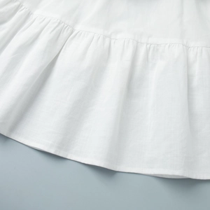 Detailed macro view of white tiered cake skirt hem with textured ruffle cotton fabric