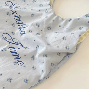 Nahaufnahme von hellblauem Canvas-Stoff mit Blumenmuster und Grakha Time Schriftzug