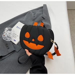 Detail view of pumpkin handbag featuring orange bat charm and festive face applique