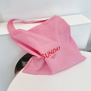 Detail of pink canvas tote bag showing red Sunday Summer Night letter printing