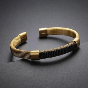Detail of gold mesh stainless steel open cuff bracelet with black textured center band