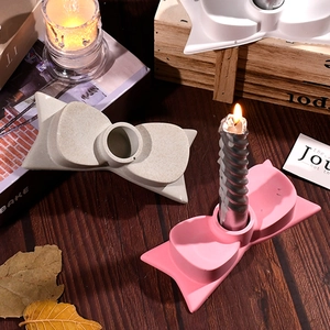 Detail von bogenförmigen Kerzenhaltern in Rosa und Beige mit mattem Finish auf Holz