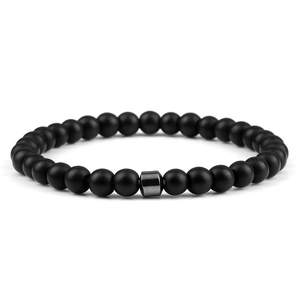 Detail of matte black stone bead bracelet featuring a silver hexagonal metal spacer bead