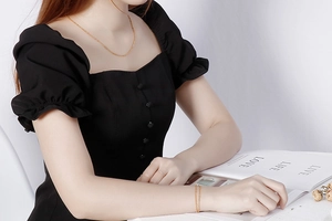 Elegant gold curb chain necklace and bracelet set shown on model in black dress