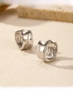 Macro detail of wide S925 silver hoop earrings with pave-set white cubic zirconia stones