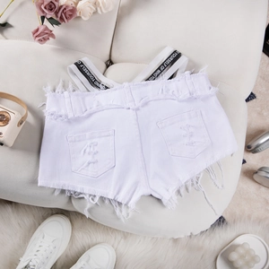 Pantaloncini di jeans bianchi strappati con spalline grafiche e bordi sfrangiati su divano